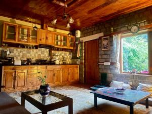 ein Wohnzimmer mit einem Tisch und einer Küche in der Unterkunft The OakHurst in Manali