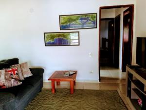 ein Wohnzimmer mit einem Sofa und einem Couchtisch in der Unterkunft Hostel Guaxinim in Caraguatatuba