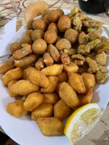 a plate of food with nuggets and a lemon slice at Agriturismo cerquatonda in Montalto delle Marche