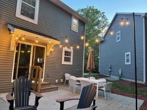 a patio with a table and chairs and a house at 'Woodhaven Hideaway' indoor pool, hot tub in South Haven