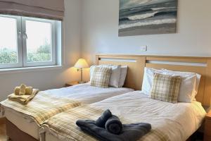 two beds sitting next to each other in a bedroom at No2 The Links Apartment, Brora in Brora