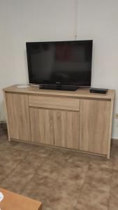 telewizor z płaskim ekranem siedzący na drewnianej szafce w obiekcie Ema w mieście Labin
