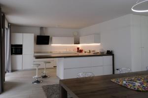 a kitchen with white cabinets and a table and chairs at SWEETHOME MUSEO - con Garage in Bolzano