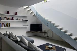 a living room with a couch and a staircase at SWEETHOME MUSEO - con Garage in Bolzano
