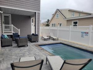 eine Terrasse mit Stühlen und einem Pool in der Unterkunft 6 Bedroom Luxury Home in Brighton Beach