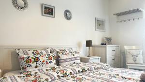 a white bedroom with a bed and pillows on it at Casa de Vacanta Potoc in Potoc
