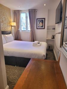 a hotel room with two beds and a tv at Atlantic Seafront in Brighton & Hove