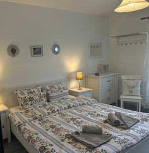 - une chambre avec un grand lit et des serviettes dans l'établissement Casa de Vacanta Potoc, à Potoc