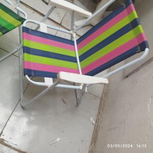 a colorful striped chair sitting on the ground at Hostel parque ecológico in Juazeiro do Norte