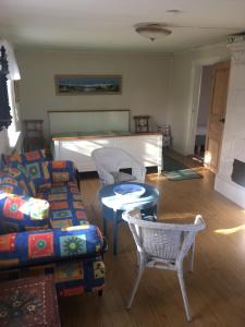 sala de estar con sofá, sillas y mesa en Enköping Cottage en Enköping