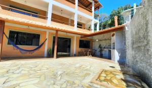 a building with a stone floor and a patio at Casa Amantes da Serra Ibitipoca - Satisfação Garantida in Conceição da Ibitipoca