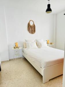 Dormitorio blanco con cama blanca y pared blanca en Ático en Sanlúcar de Barrameda, en Sanlúcar de Barrameda