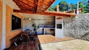 eine Küche und ein Esszimmer mit Tisch und Stühlen in der Unterkunft Casa Amantes da Serra Ibitipoca - Satisfação Garantida in Conceição da Ibitipoca