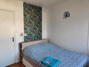 a bedroom with a bed with a blue comforter at Amaryllis in La Tronche