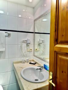 uma casa de banho com um lavatório e um espelho em Hotel La Rivera em Arenas de Cabrales