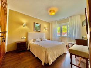a hotel room with a bed and a window at Hotel La Rivera in Arenas de Cabrales