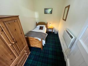 a small bedroom with a bed in a room at Ness View Cottage in Fort Augustus