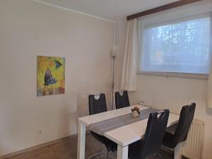 una sala da pranzo con tavolo e sedie bianchi di Appartements Kubisko a Keutschach am See