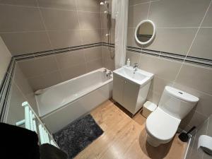 a bathroom with a toilet and a tub and a sink at Ness View Cottage in Fort Augustus