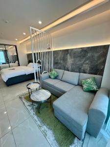 a living room with a couch and a bed at Deluxe Studio Apartments at Kass Towers Accra - Upper Floor By VP Properties in Accra