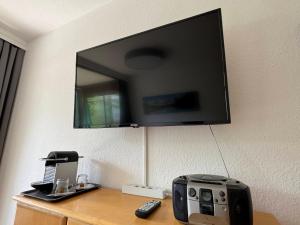 a flat screen tv hanging on a wall with a printer at Ferienwohnung an der Traun in Bad Aussee