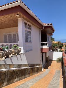Dieses weiße Haus verfügt über eine Veranda und einen Balkon. in der Unterkunft Holiday Home Austry in Tejina
