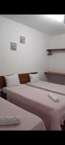 - 2 lits dans une chambre aux murs blancs dans l'établissement Pousada Verdes Mares, à Santa Cruz Cabrália