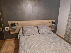 łóżko z dwiema poduszkami w sypialni w obiekcie Villa individuelle 8 personnes clim, internet w mieście Le Barcarès