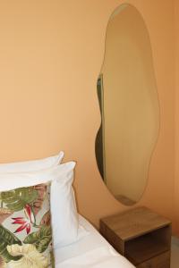 a mirror on the wall next to a bed at Hotel París in Villeta