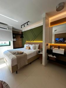 a bedroom with a large bed and a tv at Flat Praia Century Camburi in Vitória