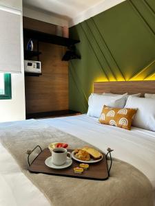 a tray with breakfast foods and coffee on a bed at Flat Praia Century Camburi in Vitória