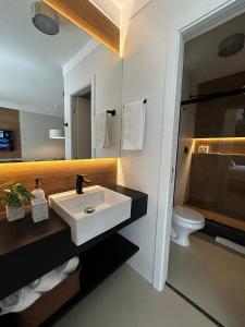 a bathroom with a sink and a toilet at Flat Praia Century Camburi in Vitória
