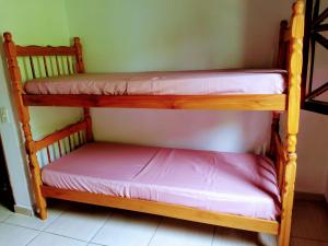 2 Etagenbetten in einem kleinen Zimmer mit in der Unterkunft Hostel Guaxinim in Caraguatatuba