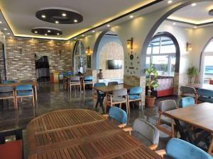 a restaurant with tables and chairs and a fireplace at Başar hotel in Erdemli