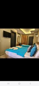 a bedroom with a large bed with blue sheets at Başar hotel in Erdemli