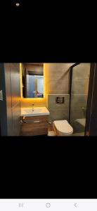 y baño con lavabo, aseo y espejo. en Basar hotel, en Erdemli