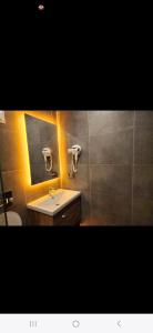 a bathroom with a sink and a mirror and a toilet at Başar hotel in Erdemli