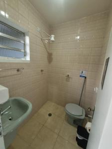 瓜魯柳斯的住宿－Villa Fátima Hostel GRU，浴室配有卫生间、盥洗盆和浴缸。