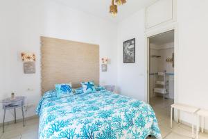 a bedroom with a bed with a blue and white comforter at Fortino Capri in Capri