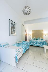 1 dormitorio con 2 camas y lámpara de araña en Fortino B&B Capri, en Capri