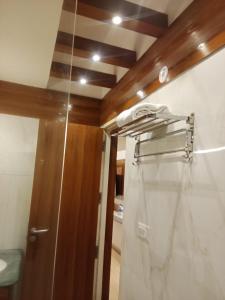 ein Bad mit einem Duschvorhang und einer Tür in der Unterkunft The Grace Residency, Lucknow in Lucknow