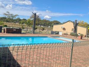 a swimming pool behind a fence at 20 Pendleberry Holiday Resort in Bela-Bela