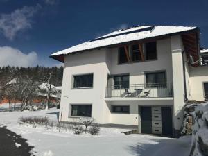 Biały dom z śniegiem na dachu w obiekcie Haus im Grünen w mieście Bad Zell