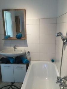 bagno con lavandino, vasca e specchio di Haus im Grünen a Bad Zell