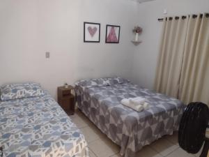 a bedroom with two beds and a stuffed animal on the bed at Casa em Uberaba com garagem in Uberaba