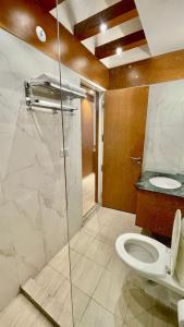 a bathroom with a toilet and a glass shower at The Grace Residency, Lucknow in Lucknow