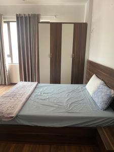sypialnia z dużym łóżkiem z niebieską pościelą w obiekcie NEHOB City w mieście Hanoi