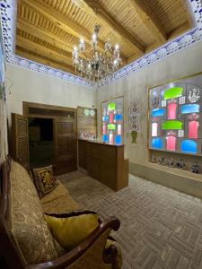 Cette chambre comprend un lustre et un canapé. dans l'établissement Asia Central Boutique, à Boukhara