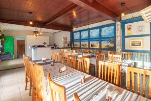 a dining room with a long table and chairs at Garden 437 Suítes in Florianópolis