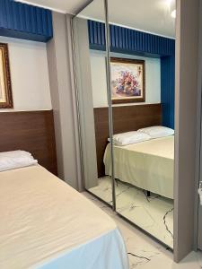 espejo en una habitación con 2 camas en Apartamento de Frente pro Mar em Balneário Camboriú, en Balneário Camboriú